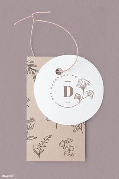 a tag with the letter d on it hanging from a string attached to a card