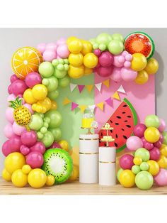 a table topped with lots of balloons and fruit