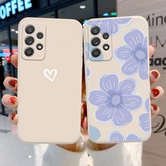 two women holding up their phone cases with flowers on them