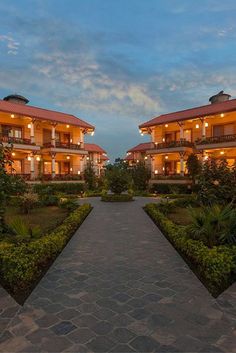 the walkway leading to two large buildings with balconies and lights on each building