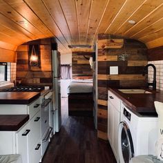 the interior of a tiny home with wood paneling on the walls and ceiling, as well as a washer and dryer