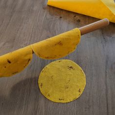 a yellow tortilla sitting on top of a wooden table next to a rolling pin