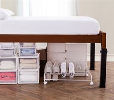 a bed with drawers underneath it and some shoes on the bottom shelf next to it