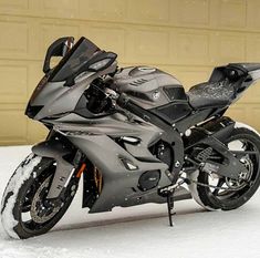 a motorcycle parked in the snow near a building