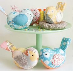 three small stuffed birds sitting on top of a table