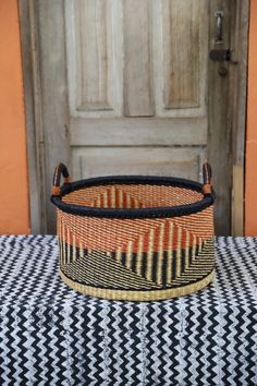 an orange and black basket sitting on top of a table