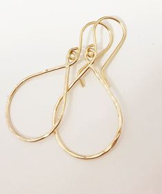 "Sleek and petite tear drop shaped hoops suspended from gold filled ear wires. Tear drop hoops is handmade with precious metal wire then hammered to textures and shine. Hoops is measure about 3/4\" x 1 inches in sizes. Hand shaped gold filled French ear wires." 14k Gold Filled Teardrop Earrings With Ear Wire, Dainty Teardrop Hoop Earrings With Ear Wire, Dainty Hammered Teardrop Earrings, Dainty Hammered Teardrop Jewelry, Everyday Teardrop 14k Gold Filled Hoop Earrings, Handmade Teardrop Yellow Gold Hoop Earrings, Simple Teardrop Earrings For Everyday, Handmade 14k Gold Filled Teardrop Earrings, Dainty Handmade Teardrop Earrings For Everyday