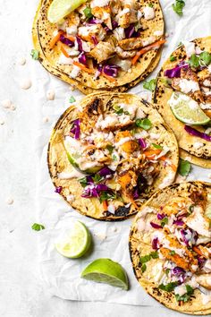 chicken tacos with cole slaw, lime and cilantro on parchment paper