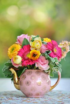 a vase filled with lots of flowers on top of a table