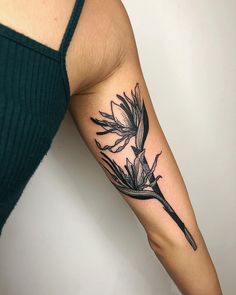 a woman's arm with a black and white bird tattoo on the left forearm