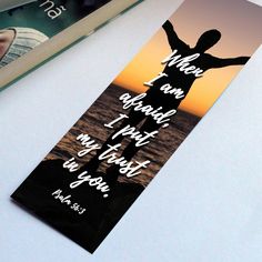 a bookmark with an image of a person raising his arms in the air and bible verse on it