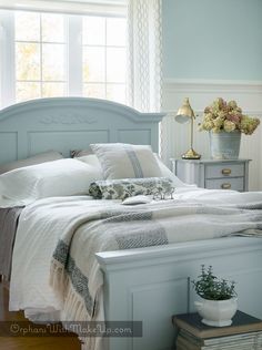 a white bed sitting in a bedroom next to a window with lots of light on it