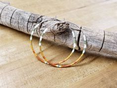 White, olive, mustard, and rust seed beads. 1 ³/⁴ inches in diameter. Nickel free hoops. Choose gold or silver hoops. Return to shop 👇 https://www.etsy.com/shop/AxeandSparrow PLEASE MAKE SURE YOUR ADDRESS IS ENTERED CORRECTLY. IF YOU ARE DOING A GUEST CHECKOUT PLEASE PLEASE DOUBLE CHECK YOUR ADDRESS AND YOUR EMAIL. THANK YOU! *All feathers are cruelty free. All hooks are lead and nickel free. All leather is genuine leather. *Please feel free to contact me with ANY questions or custom creations. Beaded Hoops, Seed Bead Earrings, Silver Hoops, Custom Creations, Boho Earrings, Delicate Bracelet, Beaded Earrings, Seed Beads, Genuine Leather