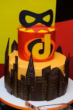 a birthday cake decorated with the number five and batman mask on it's top