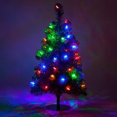 a brightly lit christmas tree in front of a dark background with colorful lights on it