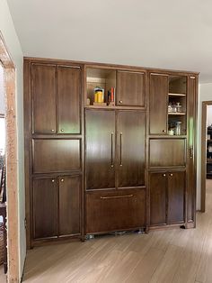 an empty room with wooden cabinets and hard wood floors