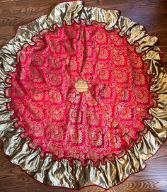 a red and gold cloth on top of a wooden floor