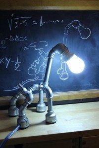 a lamp that is sitting on top of a desk in front of a blackboard