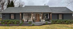 a small gray house sitting on top of a lush green field