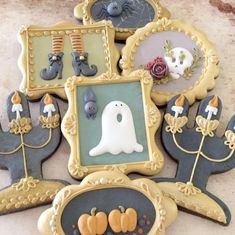 decorated cookies in the shape of frames with halloween decorations on them, sitting on a table