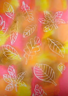 an image of leaves drawn on glass with colored light in the background and blurry