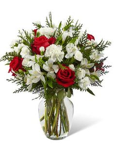 a vase filled with white and red flowers