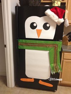 a refrigerator decorated to look like a penguin with a santa hat and scarf around its neck