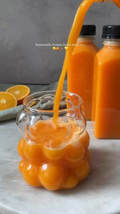 orange juice being poured into a glass bowl