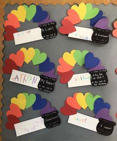 a bulletin board with lots of hearts and name tags attached to the back of it