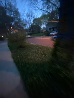 a blurry photo of cars parked on the side of a road at night time