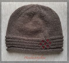 a knitted hat with red beads on it