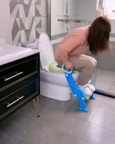 a woman is using a toilet in the bathroom