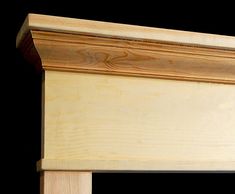 a close up of a wooden headboard on a black background with wood trimming