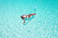 a woman is floating in the clear blue water