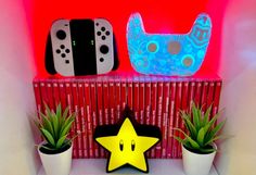 a shelf with some plants and video game controllers on it's sides, along with a yellow star