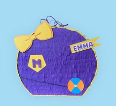 a purple piece of paper with yellow bow tie and name emma written on it