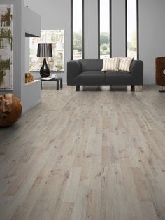 a living room with wood floors and gray furniture