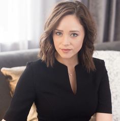 a woman sitting on top of a couch next to a window