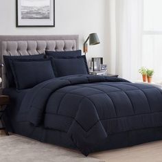 a bed with blue comforter and pillows in a room