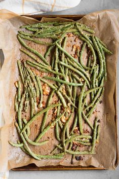 cooked green beans in parchment paper on a baking sheet