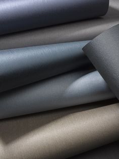 several different colors of fabric sitting on top of each other, one in grey and the other in gray