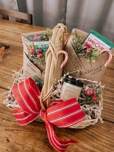 a christmas gift basket with candy canes, cookies and candies in it on a wooden table