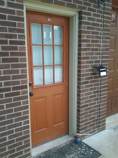 the front door to a brick building with a sign on it