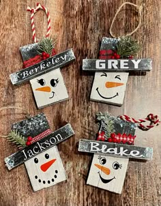 three snowmen made out of wood with christmas decorations on them and the words grey written in