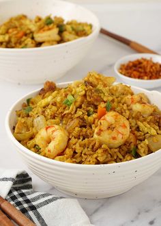 two white bowls filled with rice and shrimp