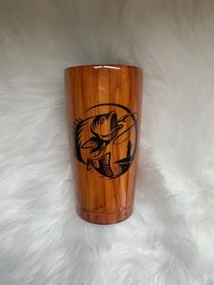 a wooden cup with a fish on it