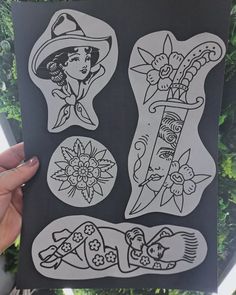 a person holding up a piece of paper with different designs on it and some flowers