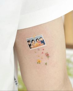 a woman's thigh with an image of two people and flowers on the side