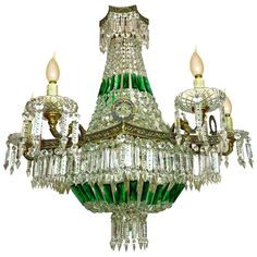 a green and gold chandelier with two candles on each one side, hanging from the ceiling