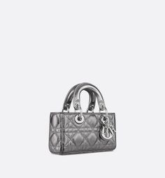 The Lady D-Joy micro bag captures the House's vision of elegance and beauty by showcasing the iconic streamlined aesthetic of the Lady Dior line. Sleek and refined, the timeless creation is crafted in metallic silver-tone Cannage calfskin and is enhanced by silver-finish metal D.I.O.R. charms. Featuring one detachable chain strap and another adjustable and removable leather strap, the Lady D-Joy bag can be carried by hand, worn over the shoulder or crossbody as an ideal day or evening companion. Lady D Joy Bag, Ideal Day, Lady D, Micro Bags, Micro Bag, Cruise Collection, Small Lady, The Lady, Arm Candy